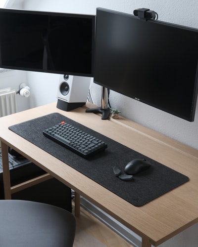 Brown wooden table in the black computer keyboard and silver imac
